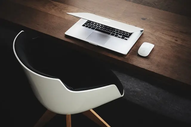 Postazione di lavoro con computer Mac e sedia nello studio dell'Avvocato Serena Callipari, specializzata in consulenza legale online e Gratuito Patrocinio.